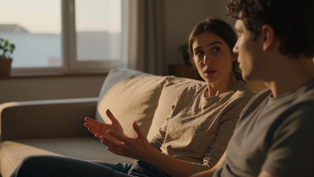 Two people having a serious conversation on a sofa in warm evening light